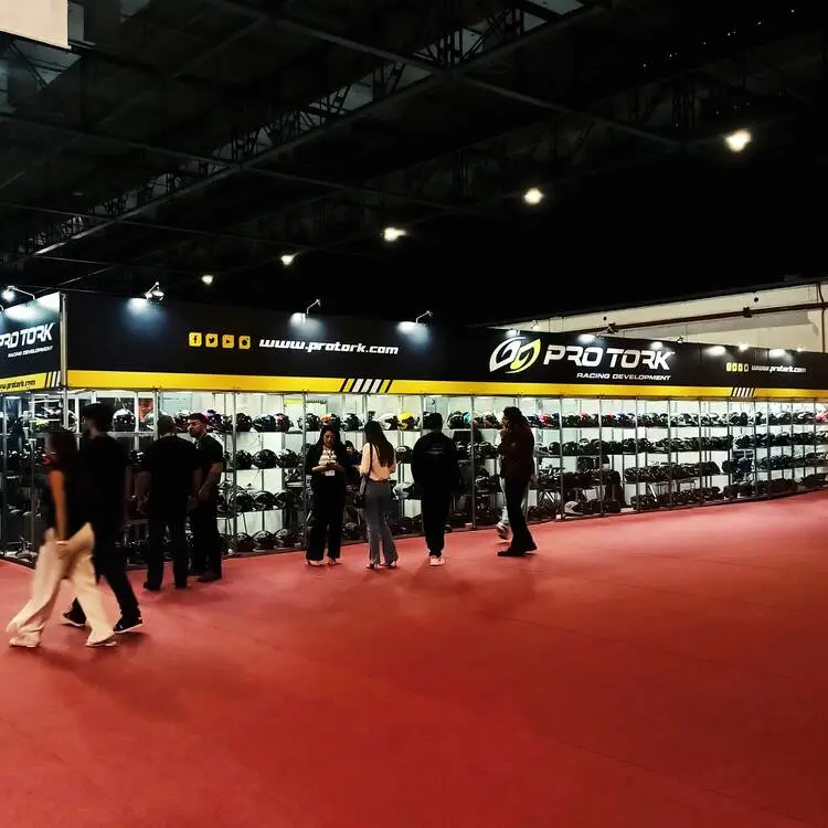 Catálogo oficial Pro Tork Argentina 2026 y pantalla de exhibición de cascos y motos en el stand del mayor fabricante de motopiezas de Sudamérica.